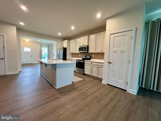 an open kitchen with white cabinets and stainless steel appliances