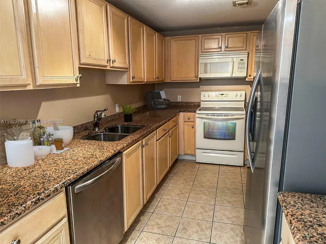 a kitchen with granite countertop white cabinets and sink