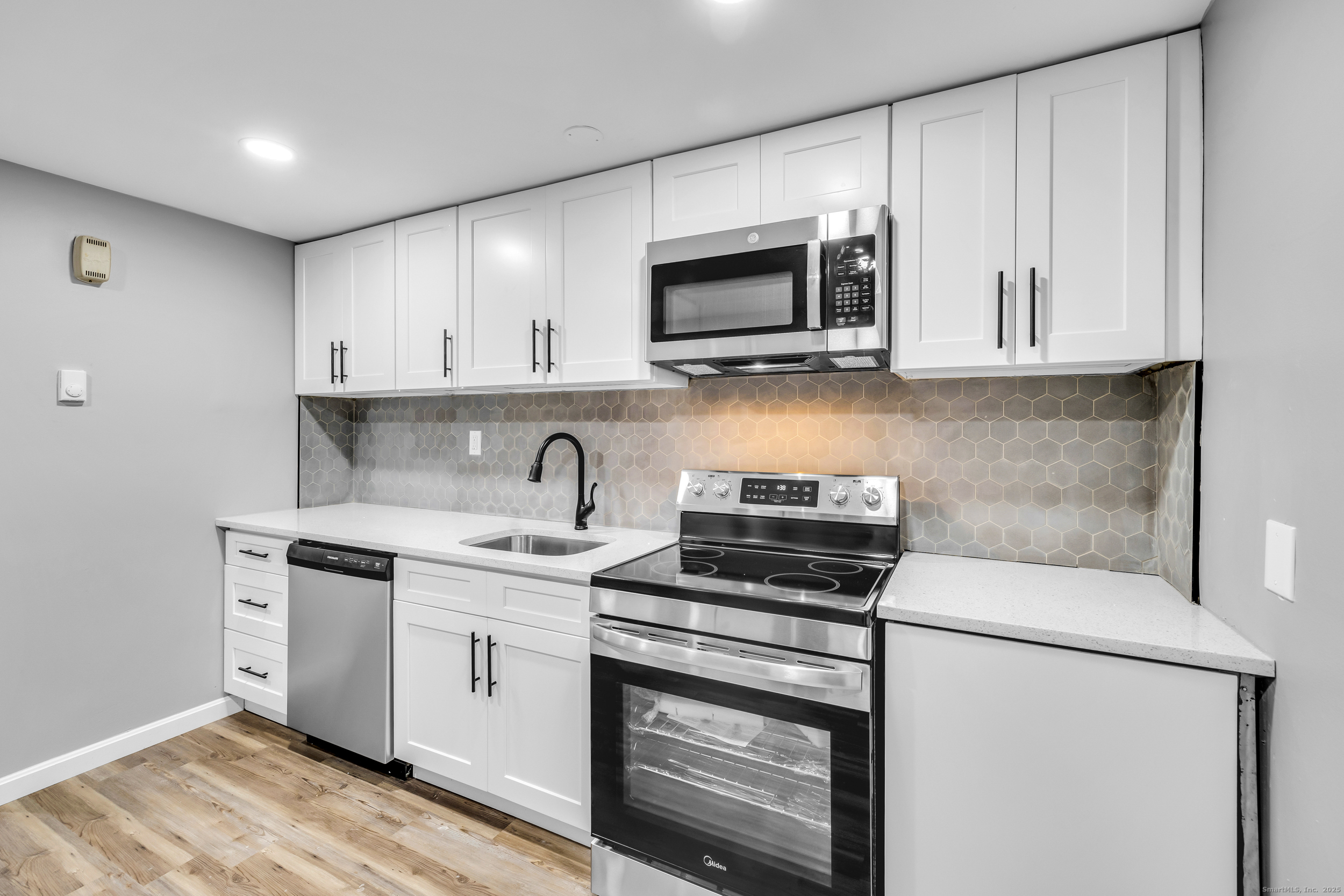 120 Gallup Hill Road, Unit 3C Ledyard, CT 06339 - Photo 3 of 14 a kitchen with stainless steel appliances granite countertop white cabinets a stove a microwave and a sink