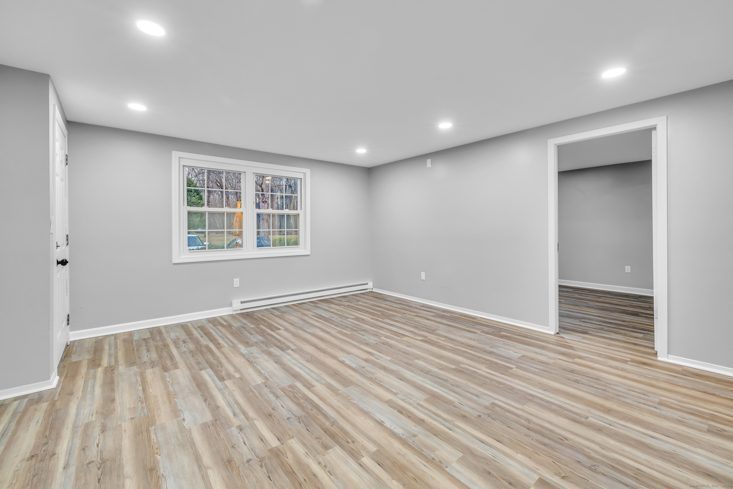 120 Gallup Hill Road, Unit 3C Ledyard, CT 06339 - Photo 7 of 14 a view of an empty room with wooden floor and a window