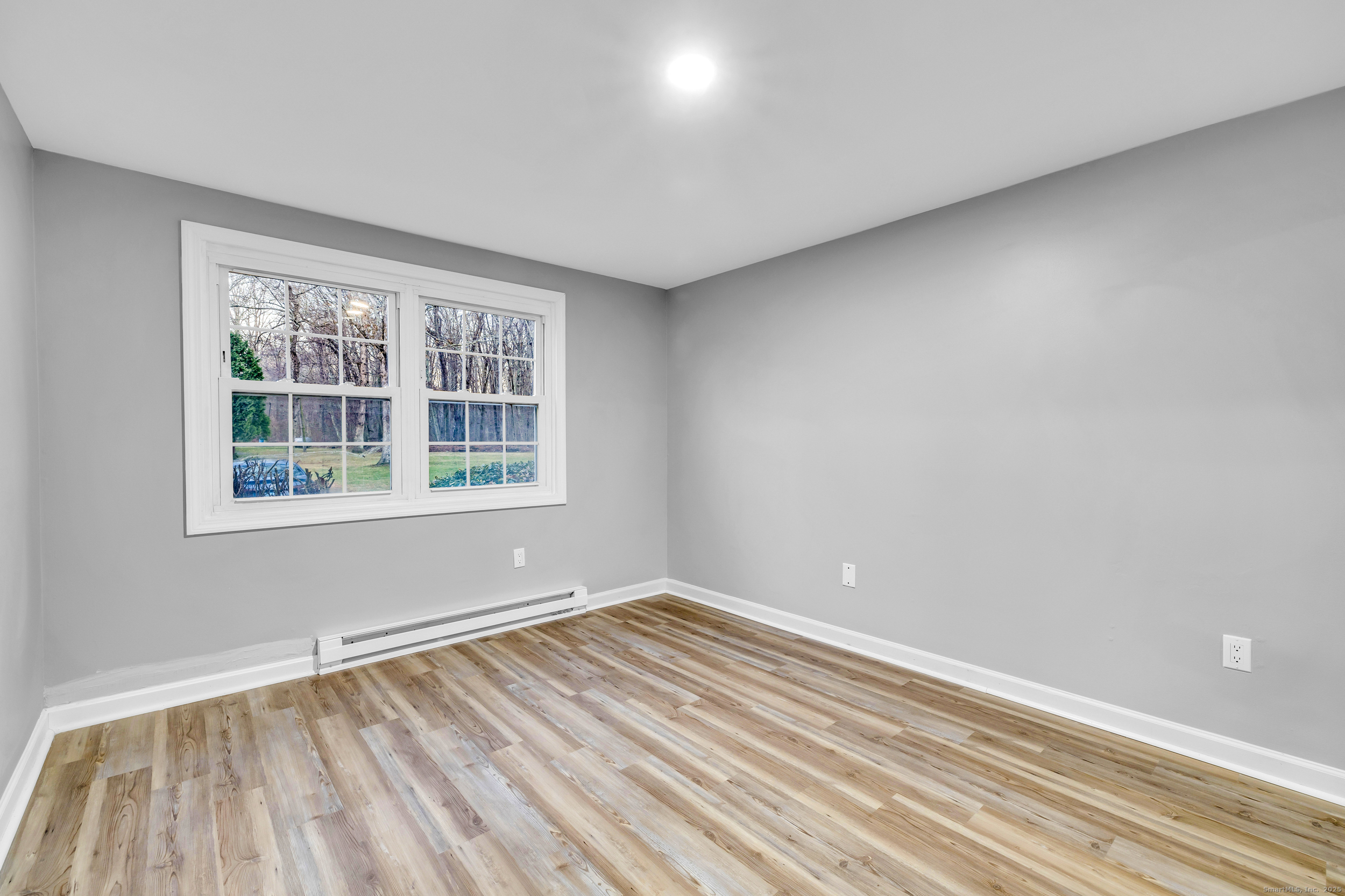 120 Gallup Hill Road, Unit 3C Ledyard, CT 06339 - Photo 9 of 14 a view of an empty room with wooden floor and a window