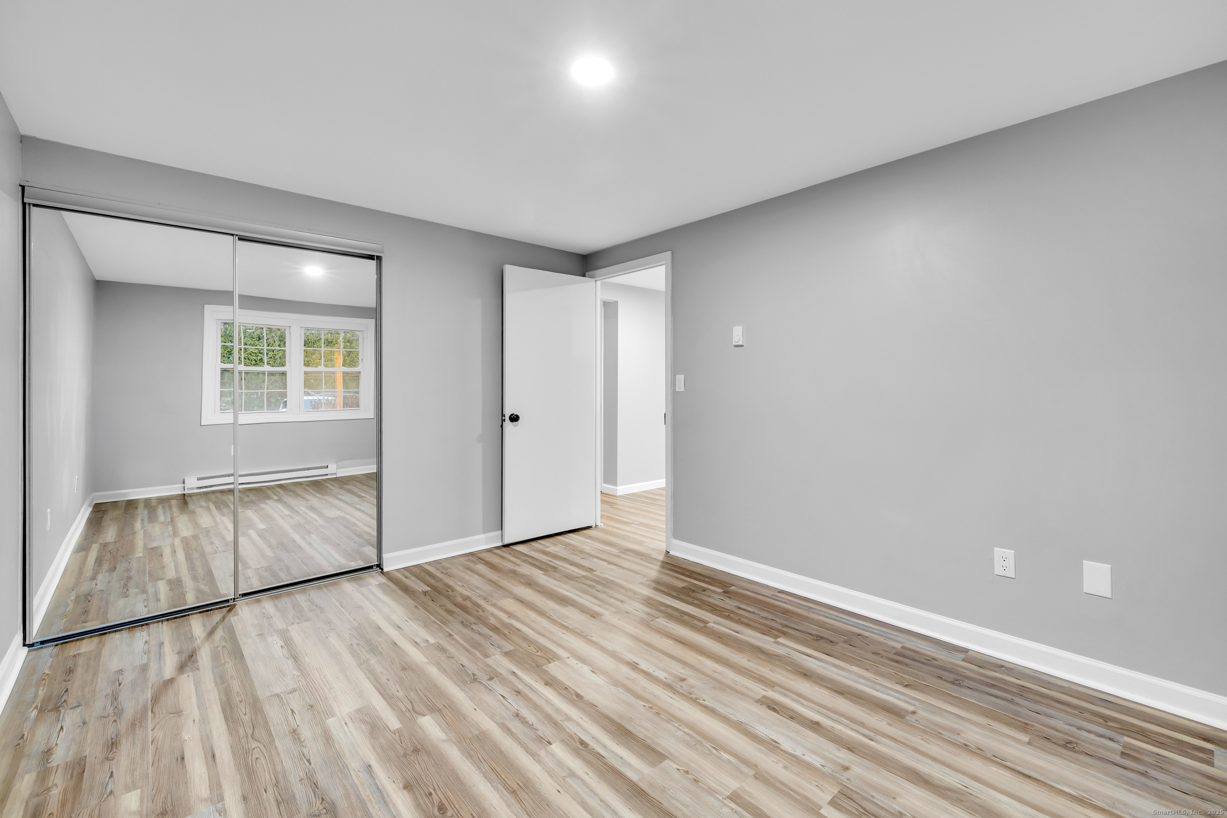 120 Gallup Hill Road, Unit 3C Ledyard, CT 06339 - Photo 10 of 14 an empty room with wooden floor and windows