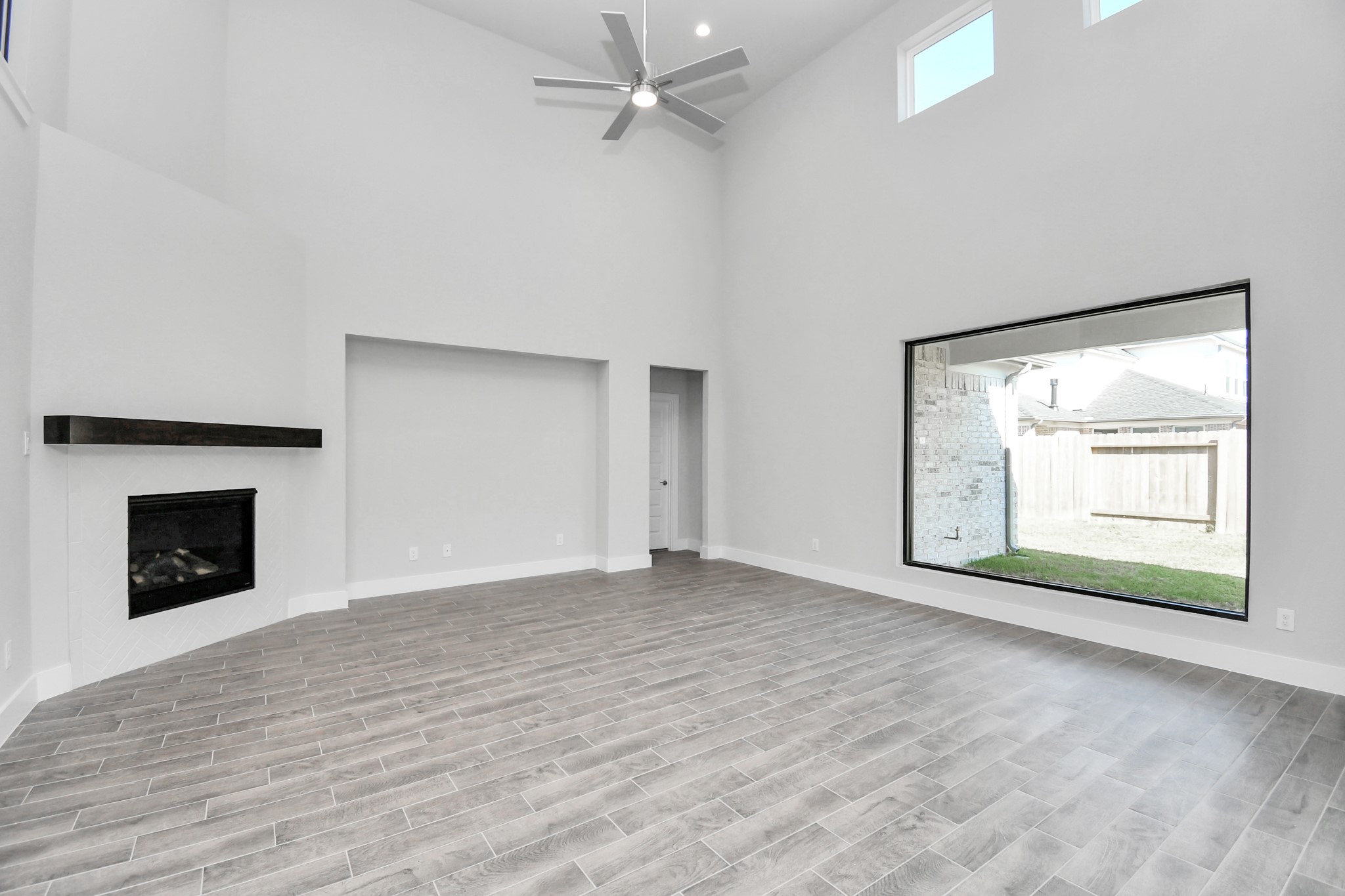 3019 Knotty Frst Drive Spring, TX 77373 - Photo 19 of 47 Family room flooded with natural light through the expansive windows. The premium tile flooring adds a touch of luxury to the space, creating the perfect setting for relaxing moments and cherished gatherings with loved ones.