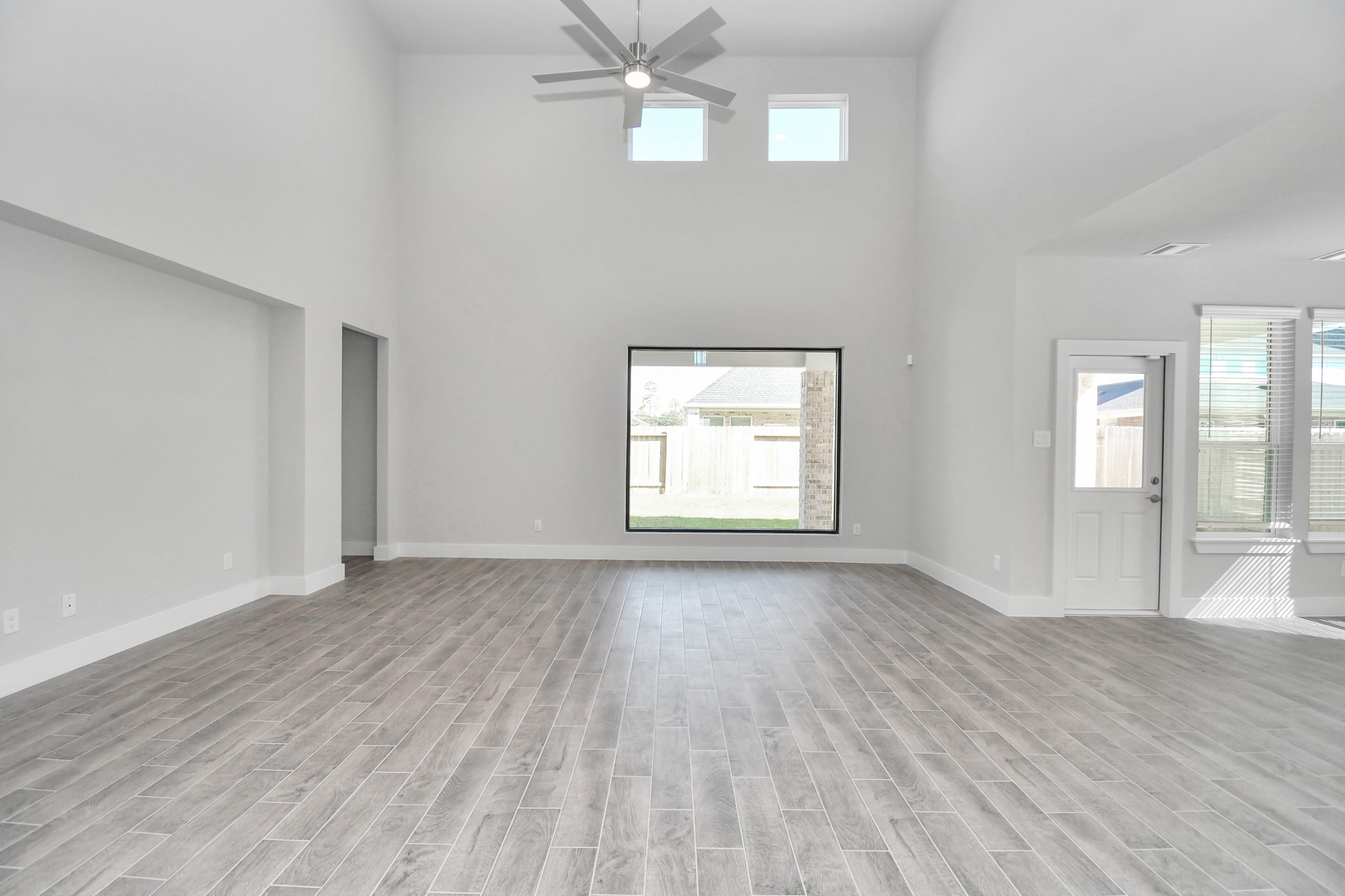 3019 Knotty Frst Drive Spring, TX 77373 - Photo 20 of 47 Relax and unwind in this inviting family room, illuminated by abundant natural light streaming in through tall windows, complemented by high ceilings and stunning flooring. Stay comfortable year-round with the gentle breeze from the ceiling fan, creating the perfect atmosphere for family gatherings.