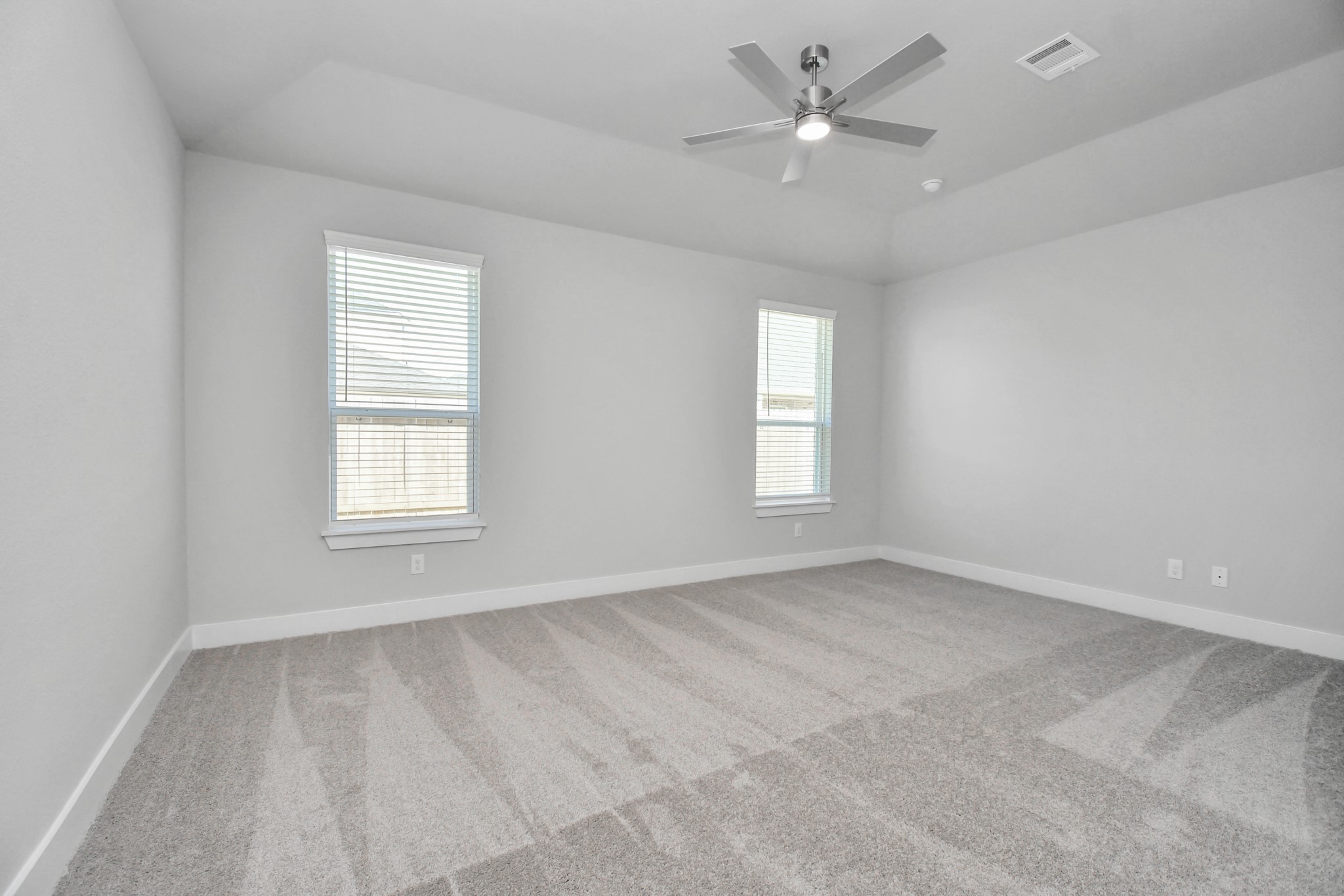 3019 Knotty Frst Drive Spring, TX 77373 - Photo 22 of 47 Retreat to the luxurious primary suite, your perfect escape for unwinding after a long day. Located on the first floor, this spacious room features plush carpeting, calming paint tones, high ceilings, and large windows with privacy blinds.