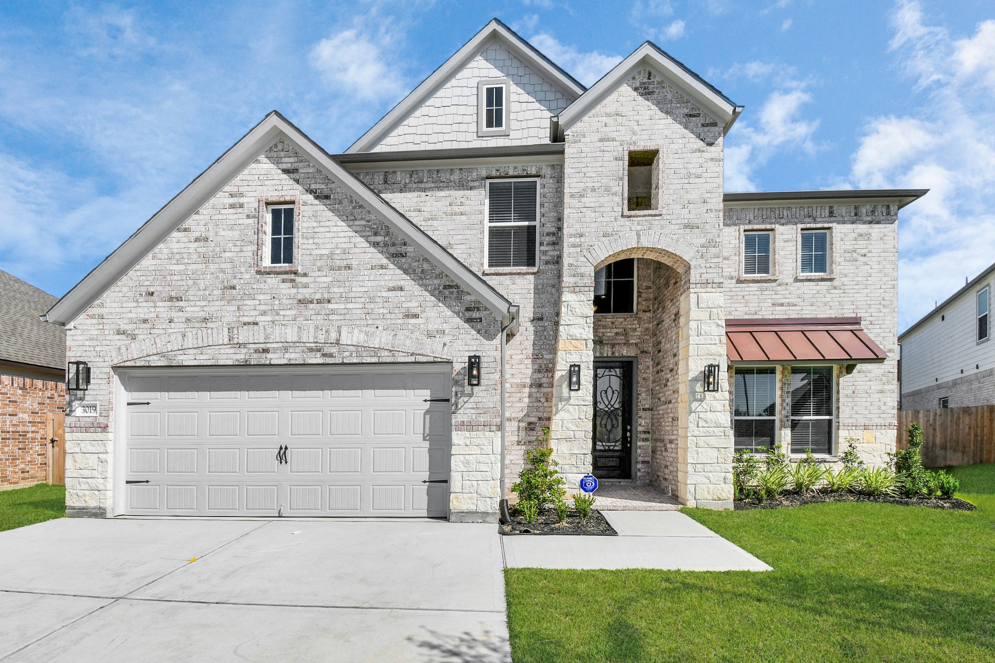 3019 Knotty Frst Drive Spring, TX 77373 - Photo 3 of 47 Meticulously maintained yard and lush landscape, paired with a premium elevation featuring captivating brick accents. Modern coach lights add a touch of contemporary elegance to the exterior.