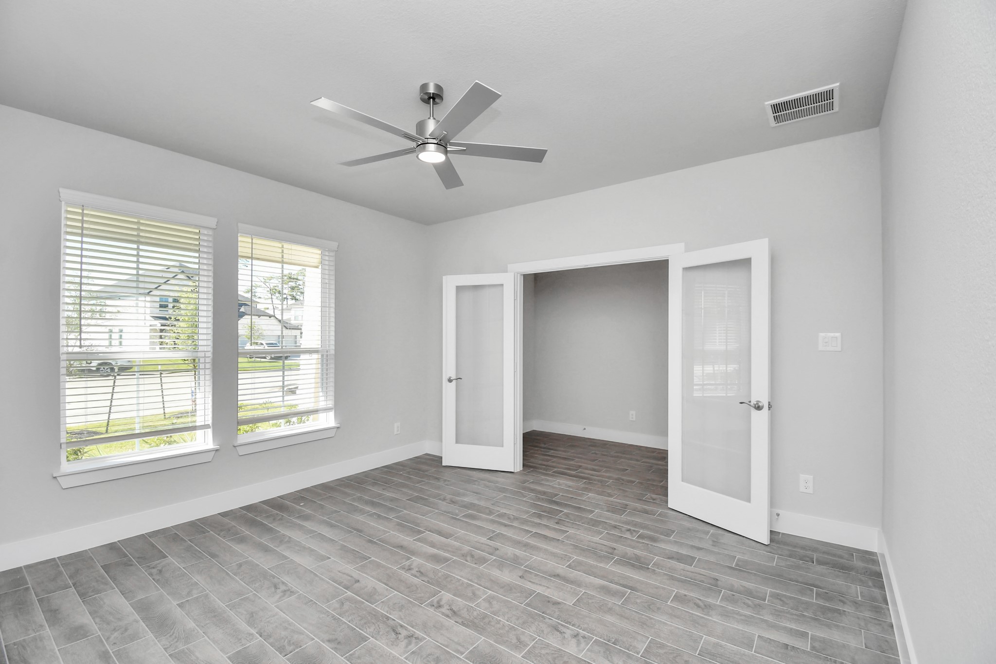 3019 Knotty Frst Drive Spring, TX 77373 - Photo 7 of 47 Experience the perfect blend of sophistication and warmth in this home office, boasting elegant wood-look tile flooring and flooded with natural light from expansive windows and French doors.