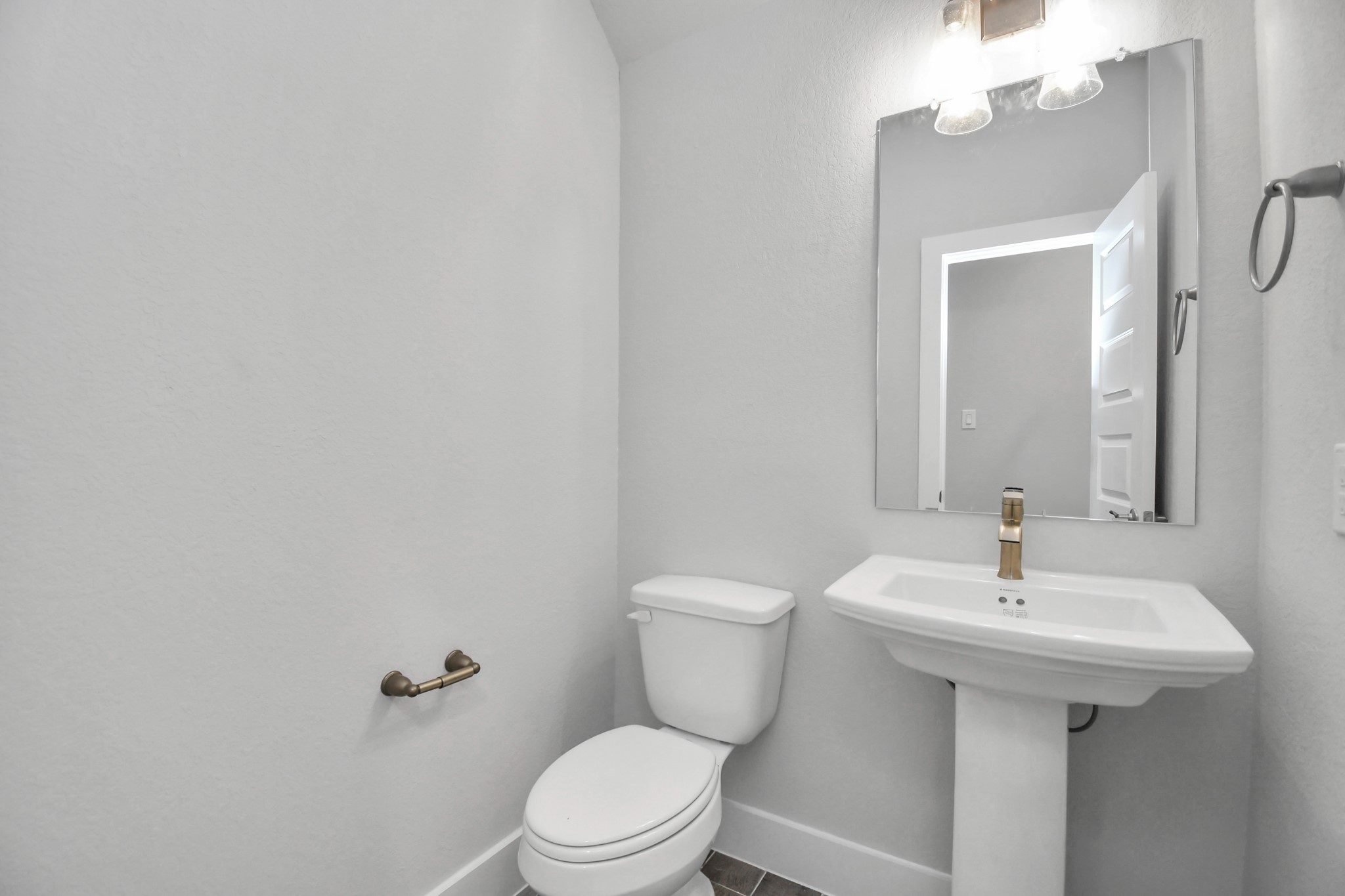 3019 Knotty Frst Drive Spring, TX 77373 - Photo 9 of 47 This half bathroom features a stylish pedestal sink, modern hardware, and bright recessed lighting, creating a sleek and inviting space.