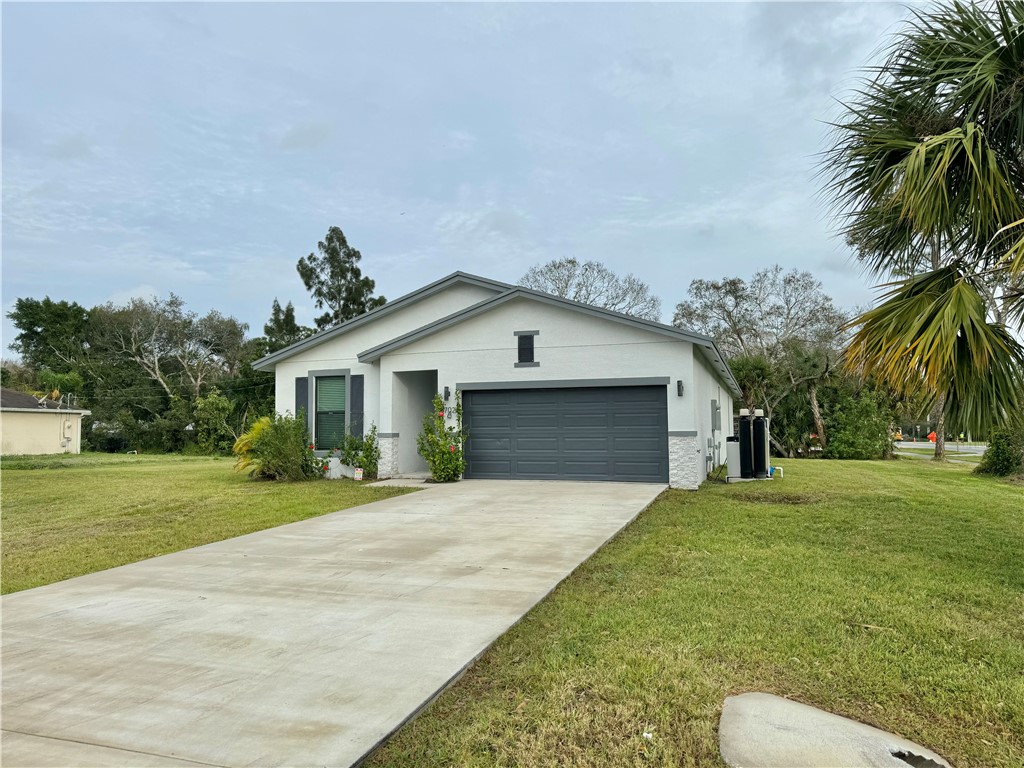 a front view of house with yard and trees in the background