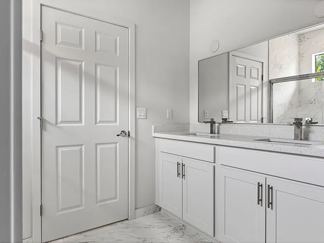 a bathroom with a double vanity sink and a mirror