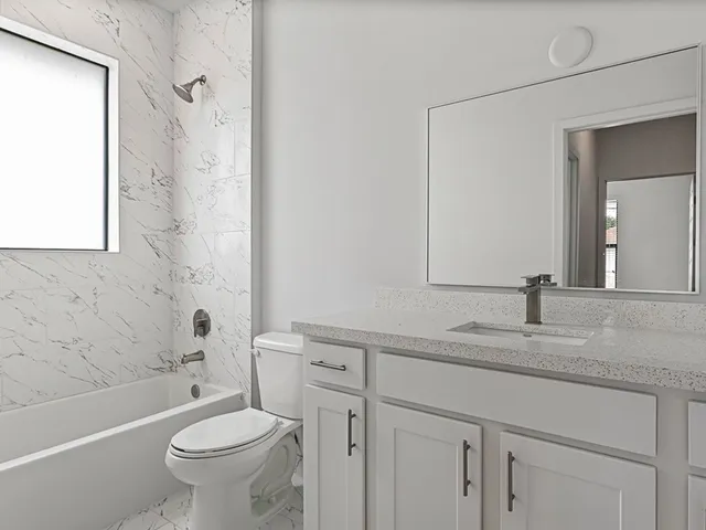 a bathroom with a sink toilet vanity and shower