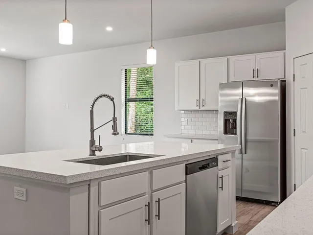 a kitchen with kitchen island a sink appliances and a counter top space