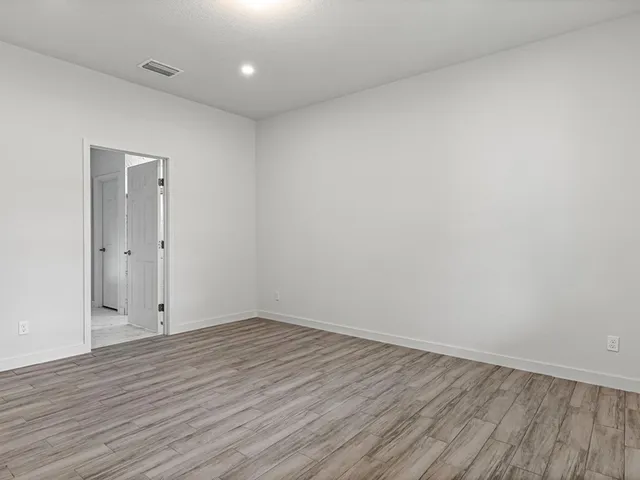 a view of an empty room with wooden floor