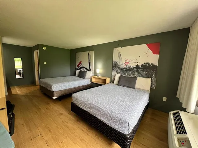 a spacious bedroom with two beds and painting on the wall