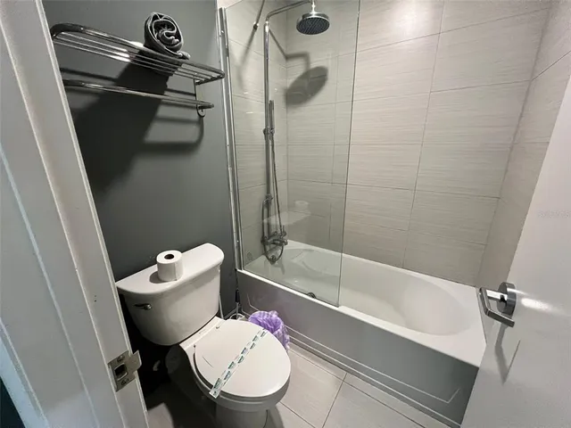 a white toilet sitting next to a bath tub