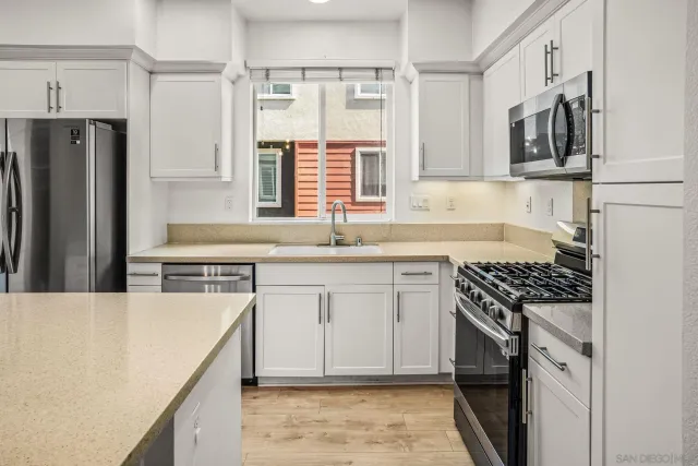 a kitchen with stainless steel appliances granite countertop a sink stove and refrigerator