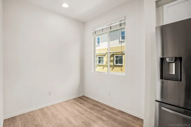 a view of kitchen with stainless steel appliances wooden floor and a window
