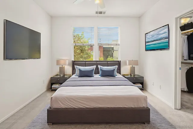 a large bed sitting in a bedroom next to a window