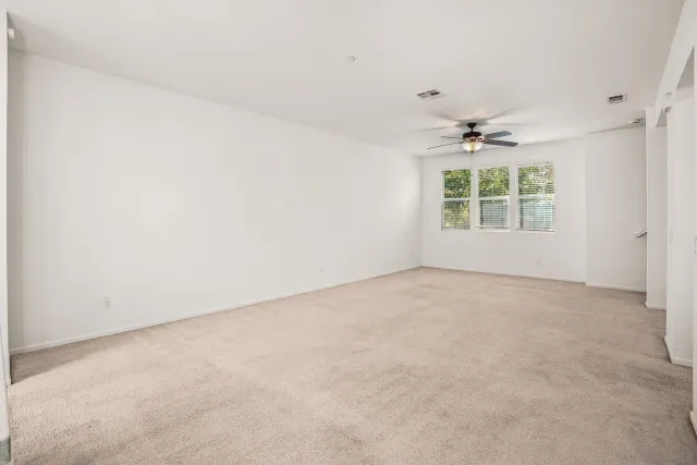 an empty room with a empty space and a ceiling fan