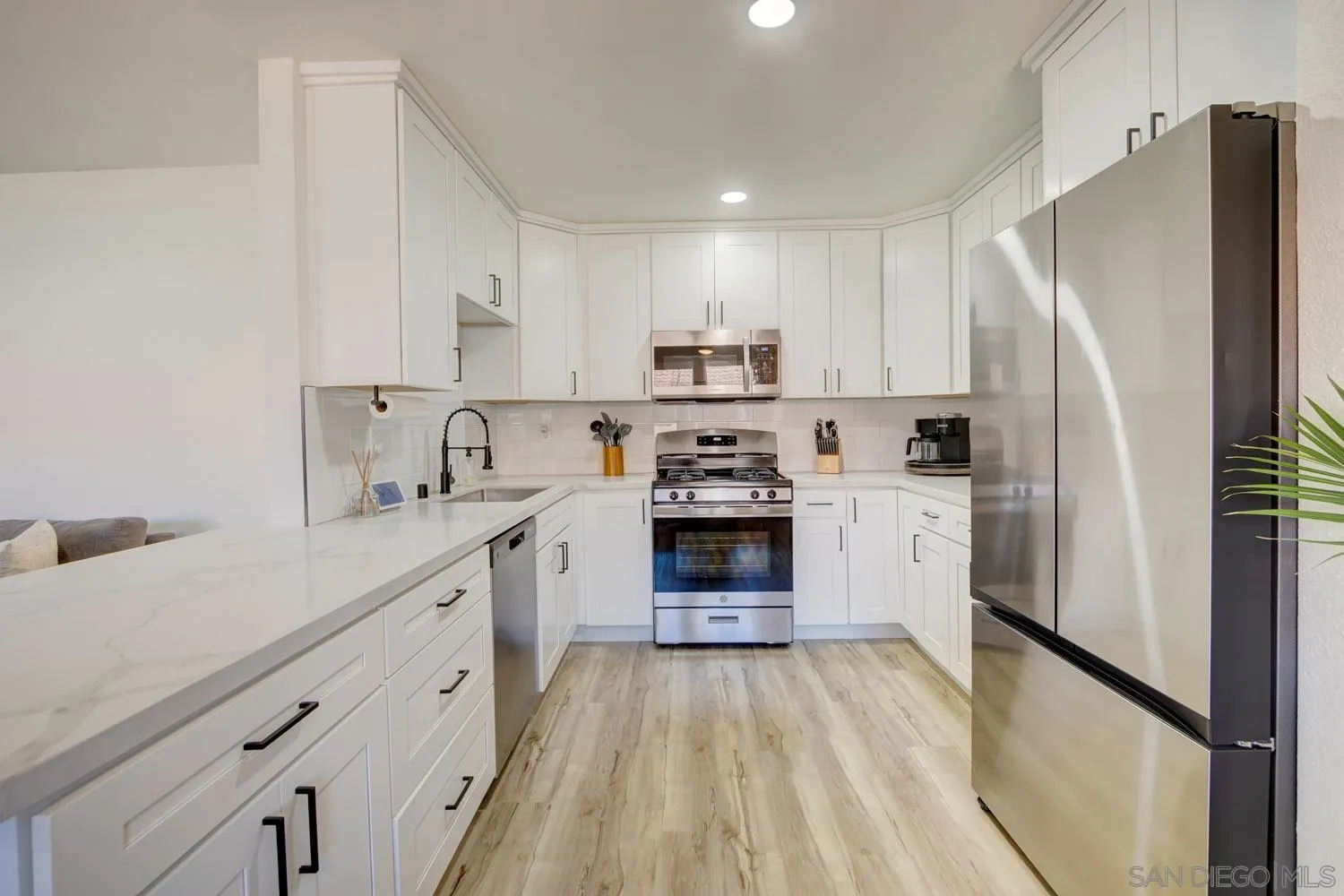 10784 Tamar Terrace, Unit C Santee, CA 92071 - Photo 22 of 33 a kitchen with white cabinets and stainless steel appliances