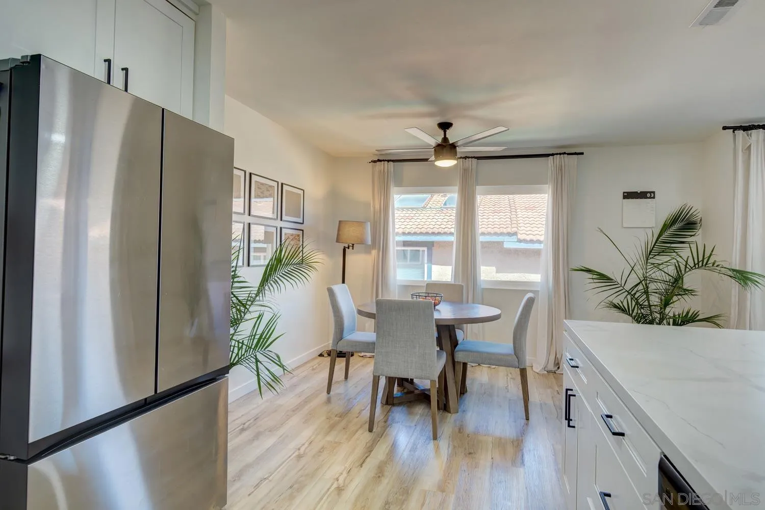 10784 Tamar Terrace, Unit C Santee, CA 92071 - Photo 26 of 33 a dining room with furniture wooden floor a potted plant and a chandelier