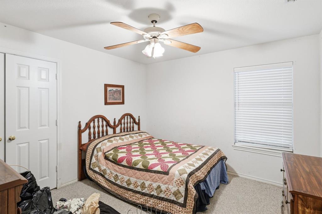 11320 Willow Springs Road Haslet, TX 76052 - Photo 15 of 28 a bedroom with a bed and a chandelier