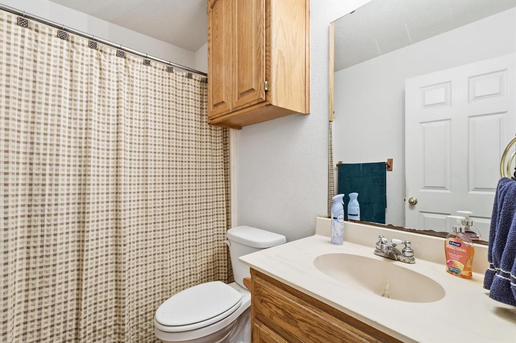 11320 Willow Springs Road Haslet, TX 76052 - Photo 16 of 28 a bathroom with a sink a toilet and shower curtain