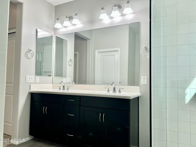 a bathroom with double sink and a mirror