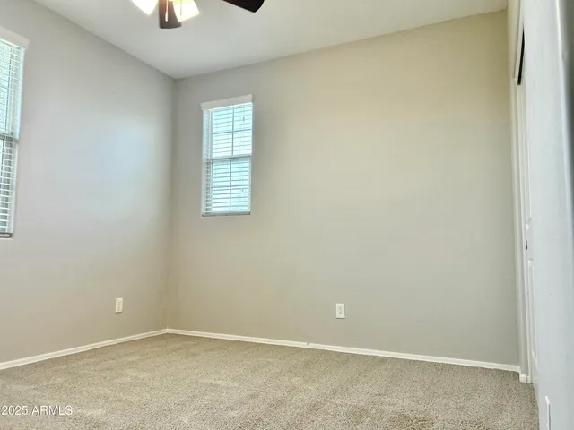 an empty room with a window and a ceiling fan