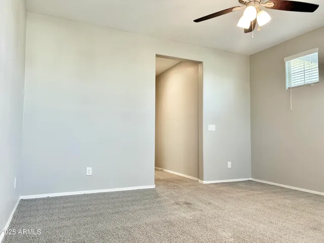 an empty room with chandelier fan