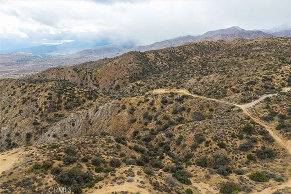 a view of a large mountain with white sky