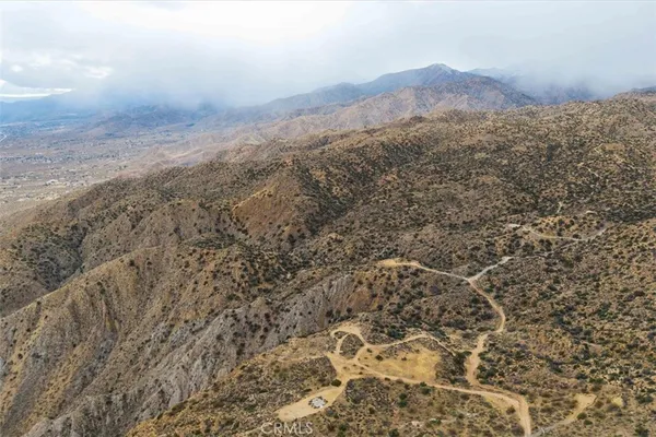 a view of a dry yard with mountains in the background