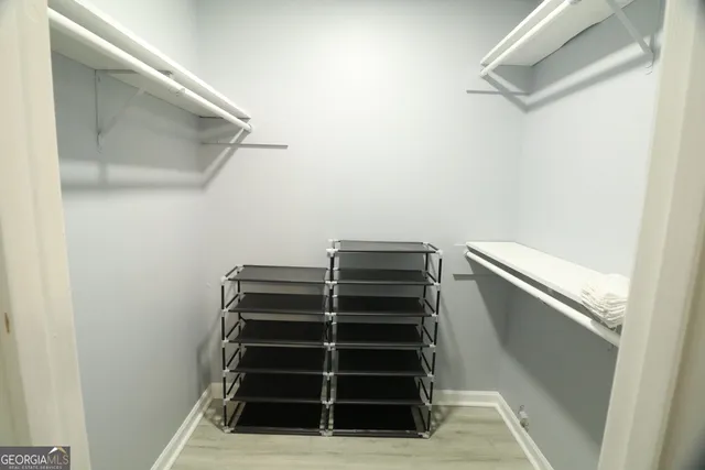 a bedroom with a bed closet and mirror