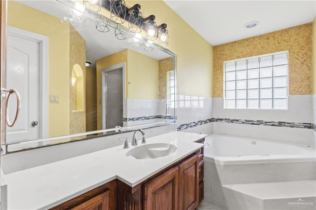 1720 East 2nd Street Weslaco, TX 78596 - Photo 12 of 17 a bathroom with a tub sink and mirror