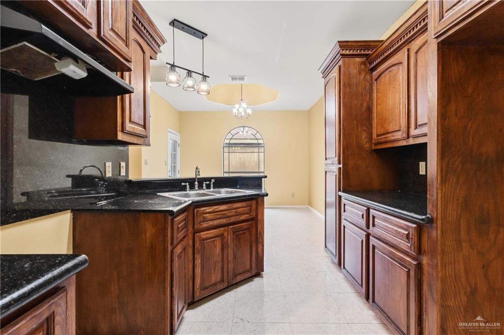 1720 East 2nd Street Weslaco, TX 78596 - Photo 10 of 17 a kitchen with granite countertop a sink stainless steel appliances a counter space and cabinets