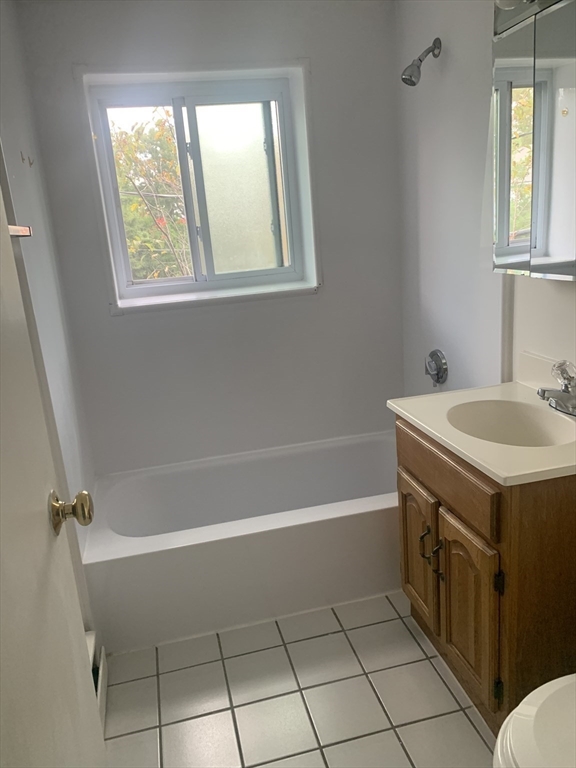 22 Bryon Road, Unit 3 Boston, MA 02467 - Photo 12 of 16 a bathroom with a bathtub a sink a vanity and a shower