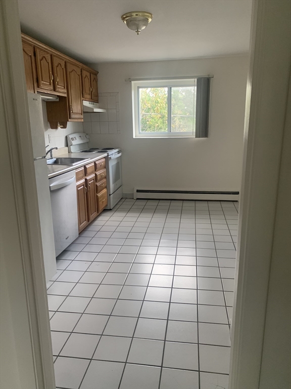 22 Bryon Road, Unit 3 Boston, MA 02467 - Photo 5 of 16 a kitchen with stainless steel appliances a sink and cabinets