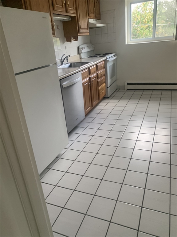 22 Bryon Road, Unit 3 Boston, MA 02467 - Photo 6 of 16 a kitchen with a sink cabinets and a stove top oven