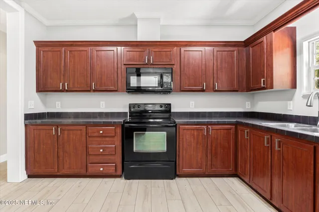 a kitchen with stainless steel appliances granite countertop wooden cabinets and a stove top oven