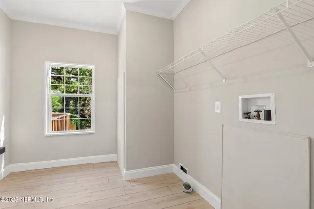 a view of a small space with wooden floor and a window