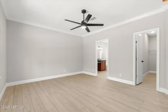 a view of empty room with wooden floor and ceiling fan