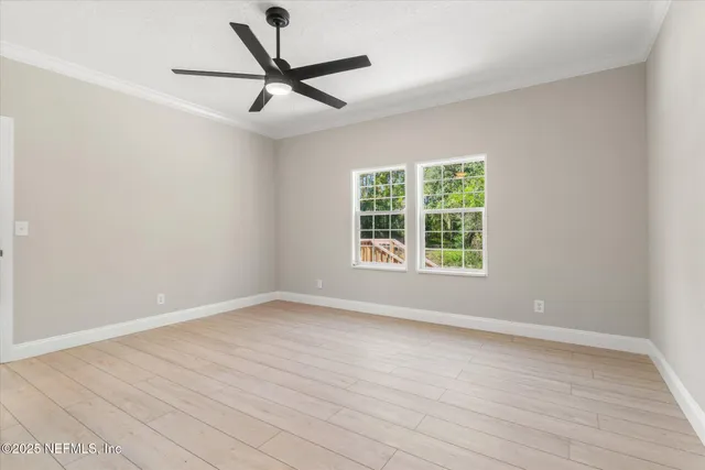 a view of a room with wooden floor and a window