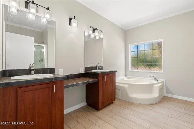 a spacious bathroom with a tub sink and mirror
