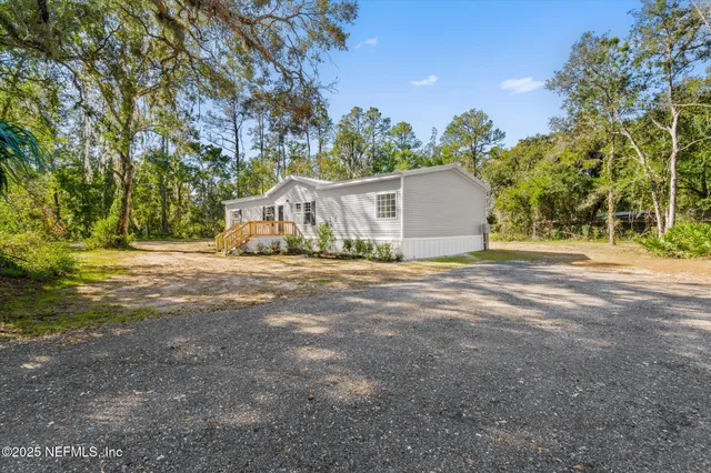 a view of a house with yard and trees