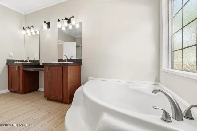 a bathroom with a tub sink and mirror