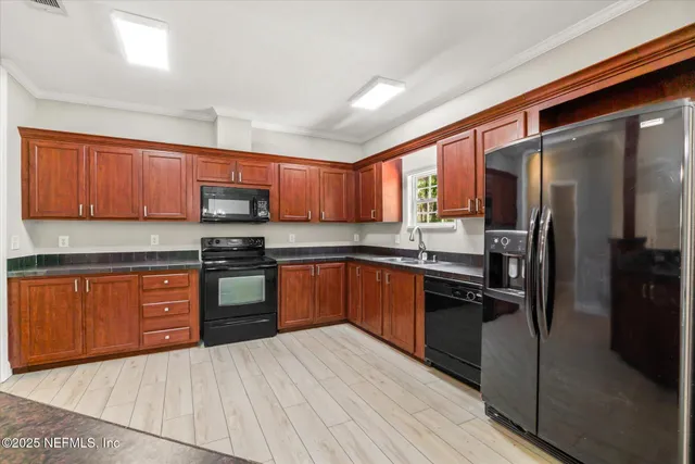 a kitchen with stainless steel appliances granite countertop a refrigerator stove top oven and sink