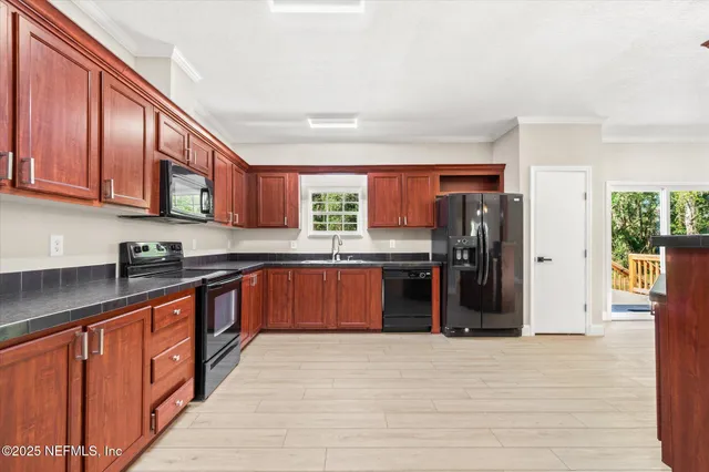 a kitchen with stainless steel appliances granite countertop a refrigerator and a sink