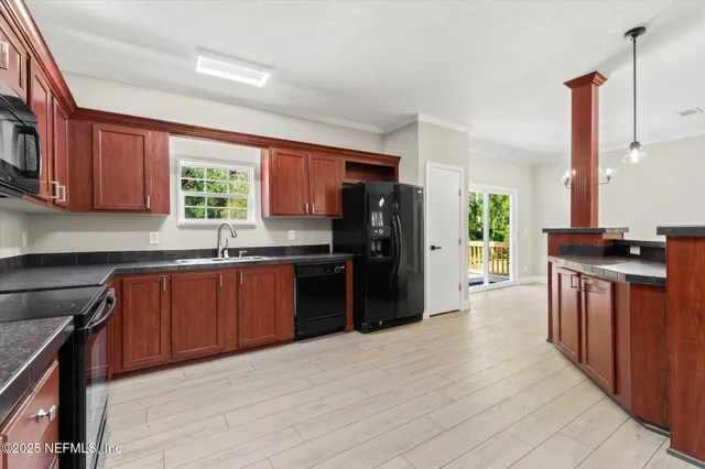 a kitchen with stainless steel appliances granite countertop a refrigerator a sink dishwasher a stove top oven a refrigerator and dishwasher