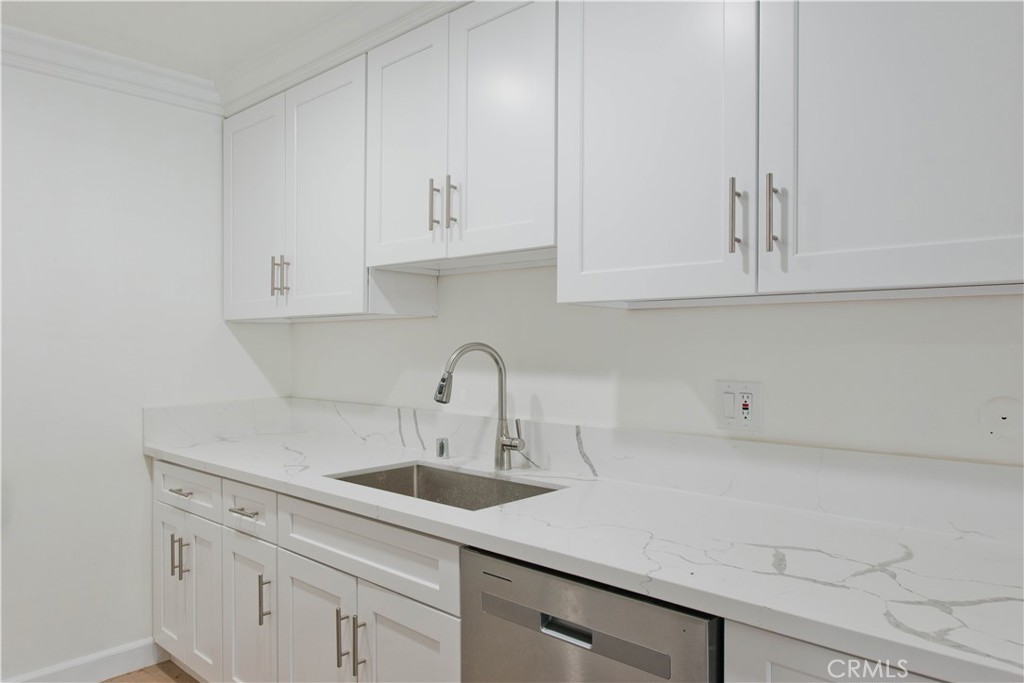 5415 Newcastle Avenue, Unit 18 Encino, CA 91316 - Photo 2 of 25 a kitchen with white cabinets and a sink