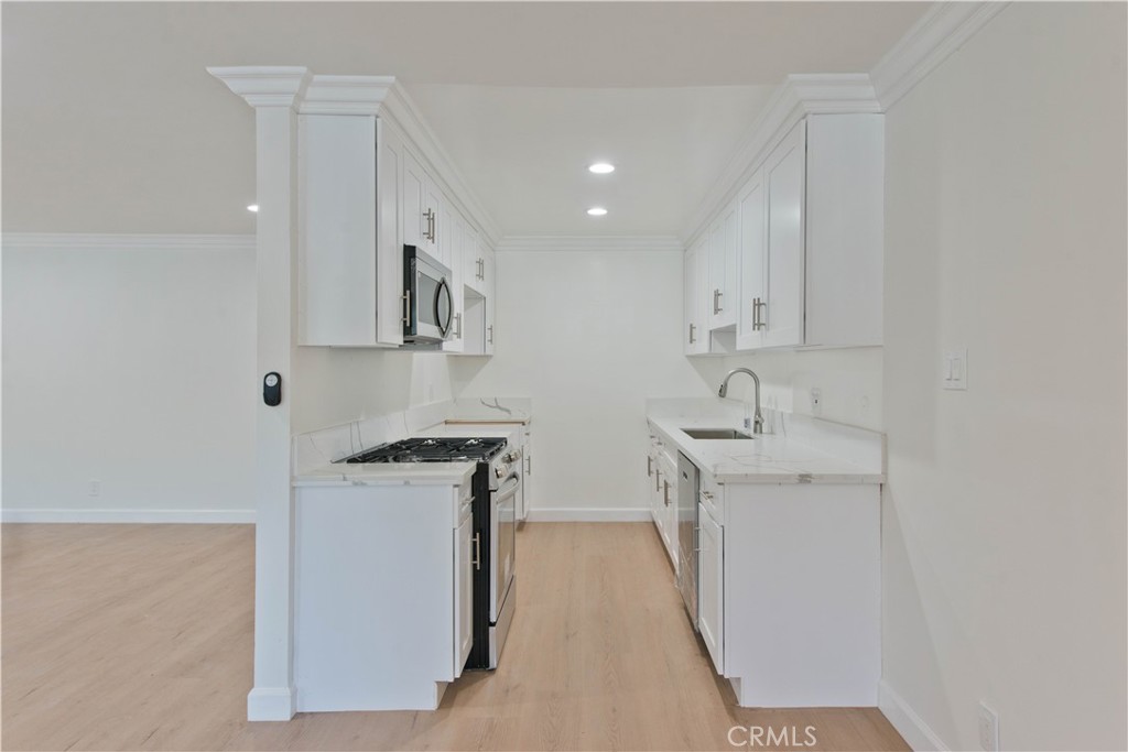 5415 Newcastle Avenue, Unit 18 Encino, CA 91316 - Photo 4 of 25 a kitchen with stainless steel appliances granite countertop a sink stove and refrigerator
